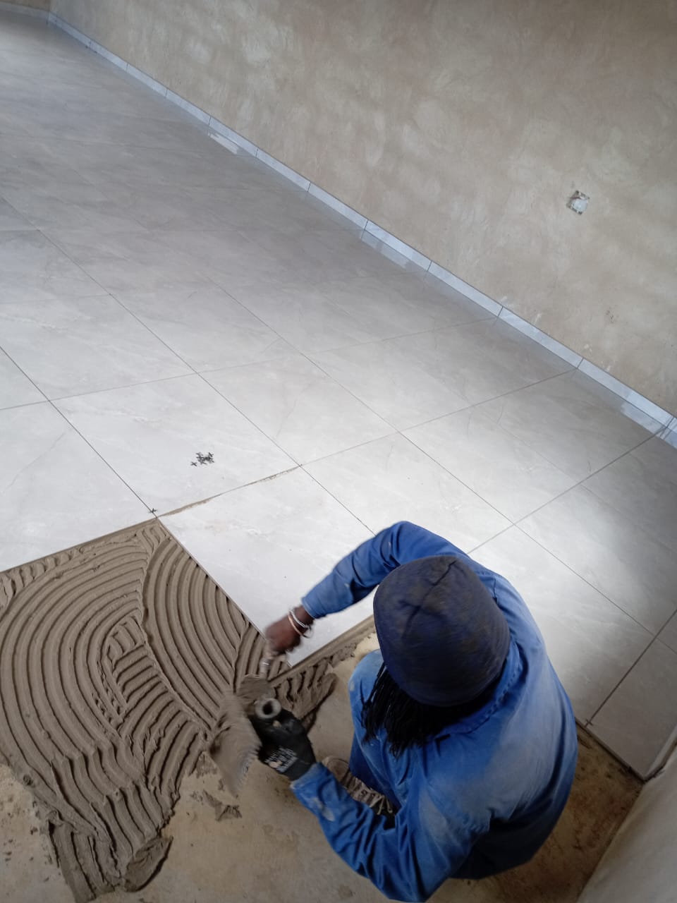 Professional tiler aligning ceramic tiles for seemless pattern