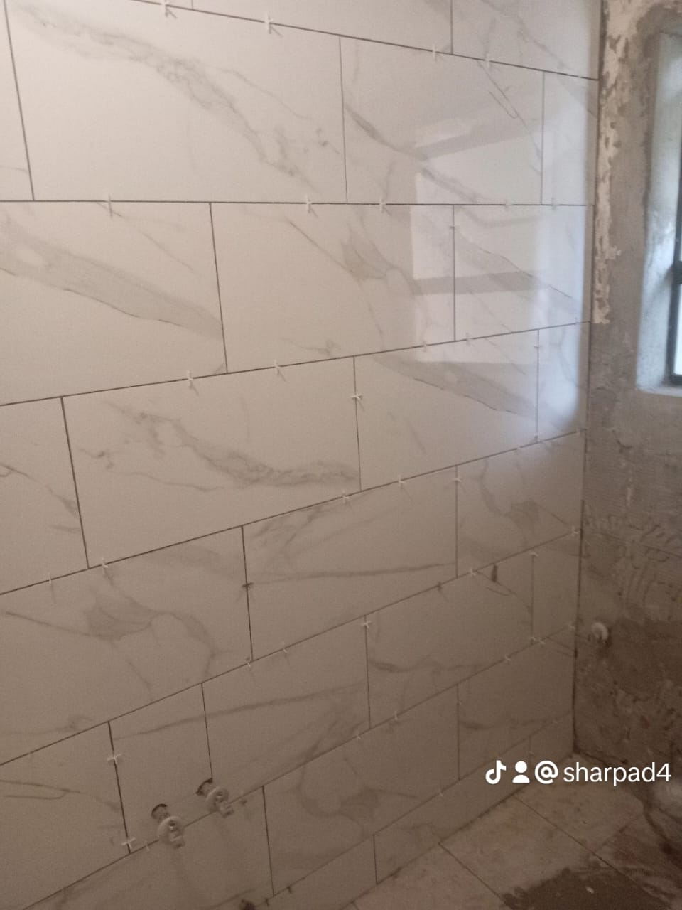 Professional tiler aligning ceramic tiles for seemless pattern